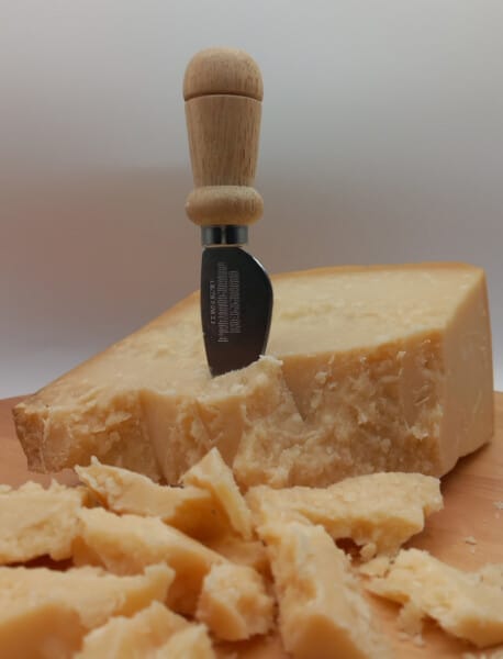 Scagliatore o coltello per tagliare il Parmigiano Reggiano infilzato in una punta di Parmigiano
