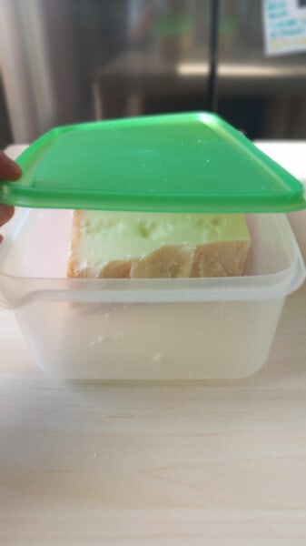 Tupperware in plastica con dentro Parmigiano Reggiano