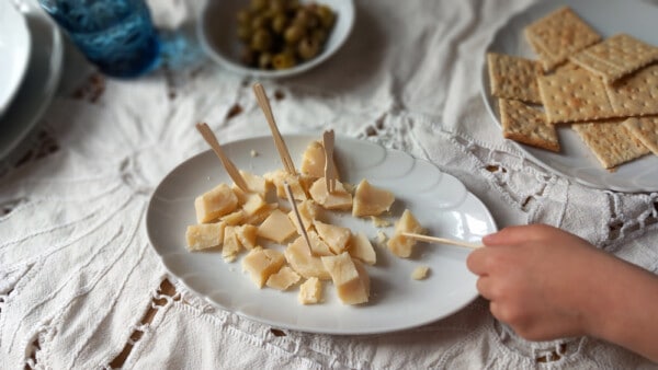 Scaglie di Parmigiano Reggiano DOP su un piatto bianco durante aperitivo
