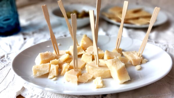 Scaglie di Parmigiano Reggiano per aperitivo in un piatto bianco